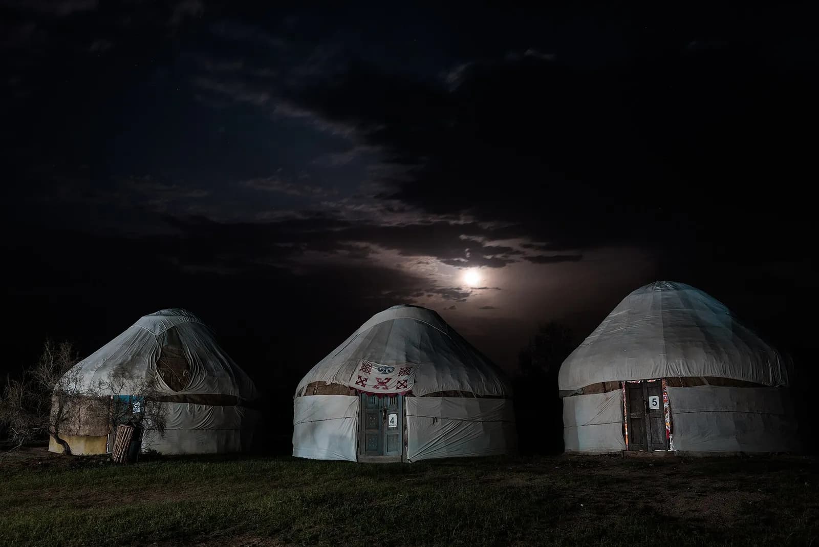 Kazakh yurts under the moon at a desert camp in the Kyzylkum