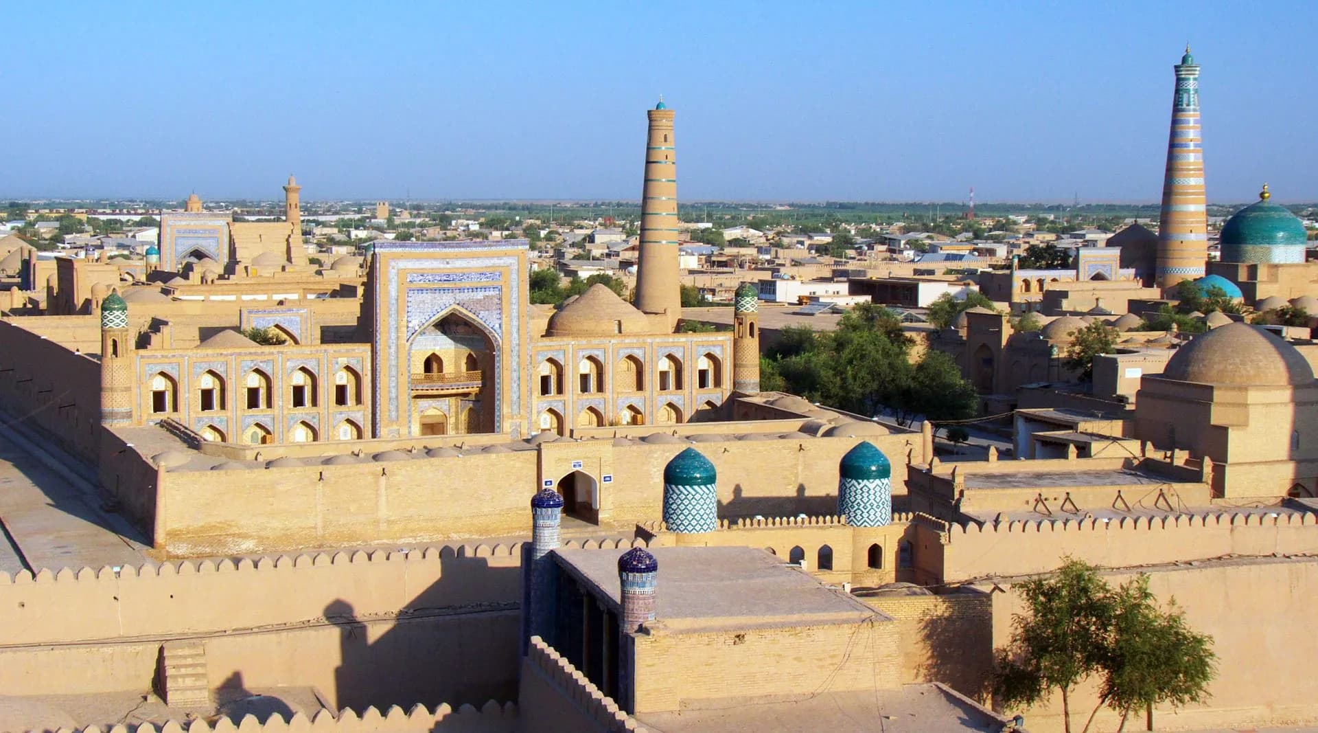 Tiled madrasas and turquoise domes of Khiva seen from the city walls